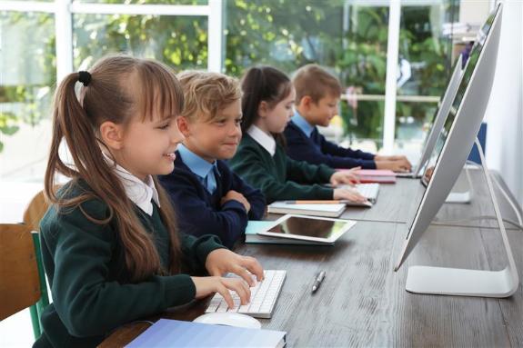 School children sitting at computer desks