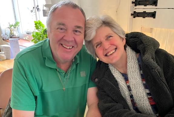 Sue and Des smile at the camera happily. They foster children with special educational needs or disabilities