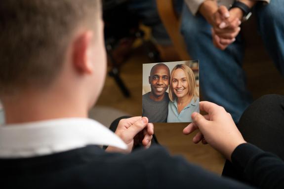Tom is looking at a photograph of his new foster carers